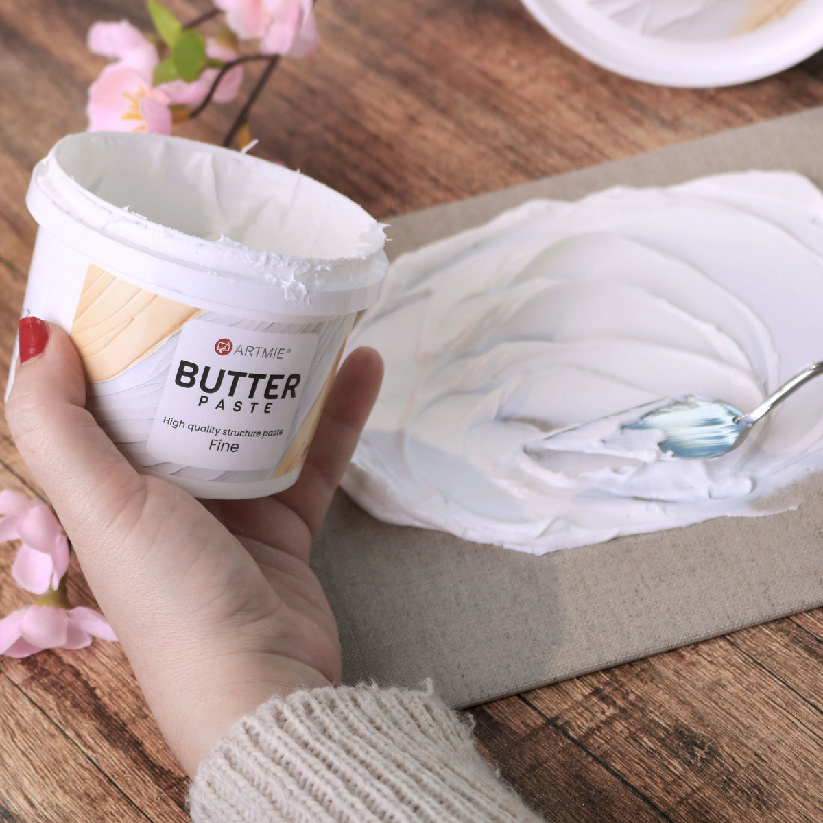 Odprta posodica in sloj paste ARTMIE Butter Fine, nanesen na platno z lopatico